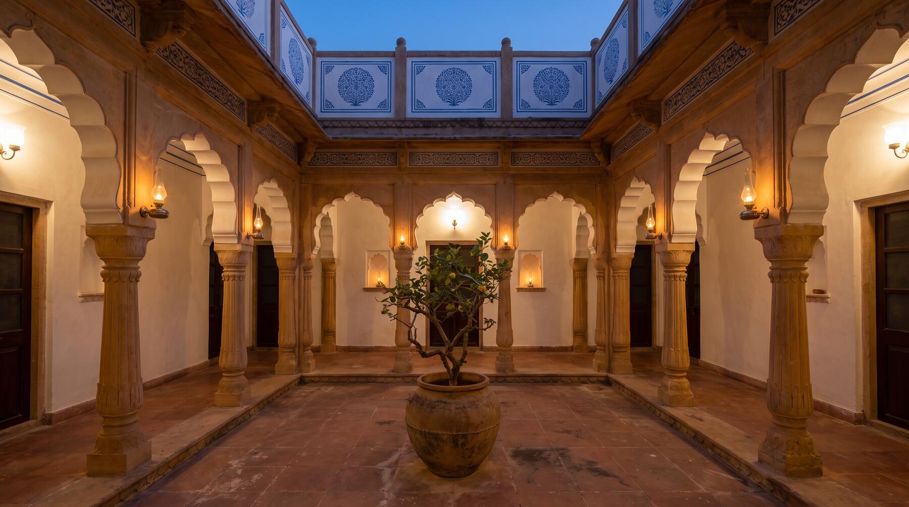 The courtyard of Kothi Ninety at dusk, lit from the arcades