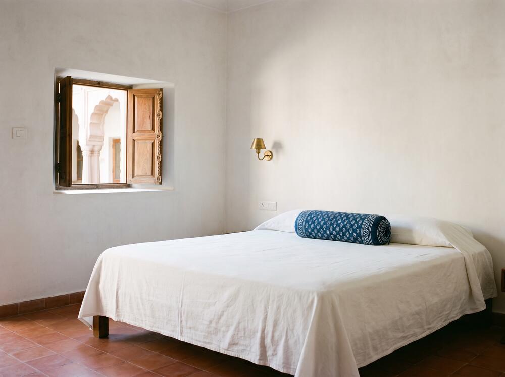 Courtyard Room, with a low bed and a window onto the arcade
